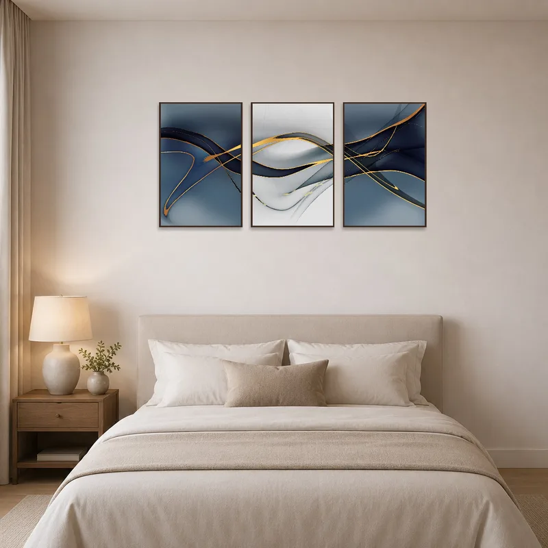 Elegant abstract triptych with gold touches above a serene bedroom bed.