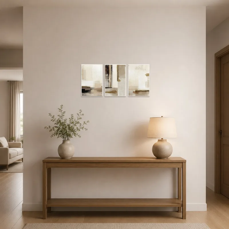 Earthy tones abstract triptych art set enhances an entrance hall with plants nearby.