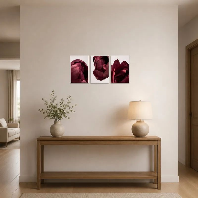 Triptych set featuring deep red flowers displayed in an entrance hall above a console table.