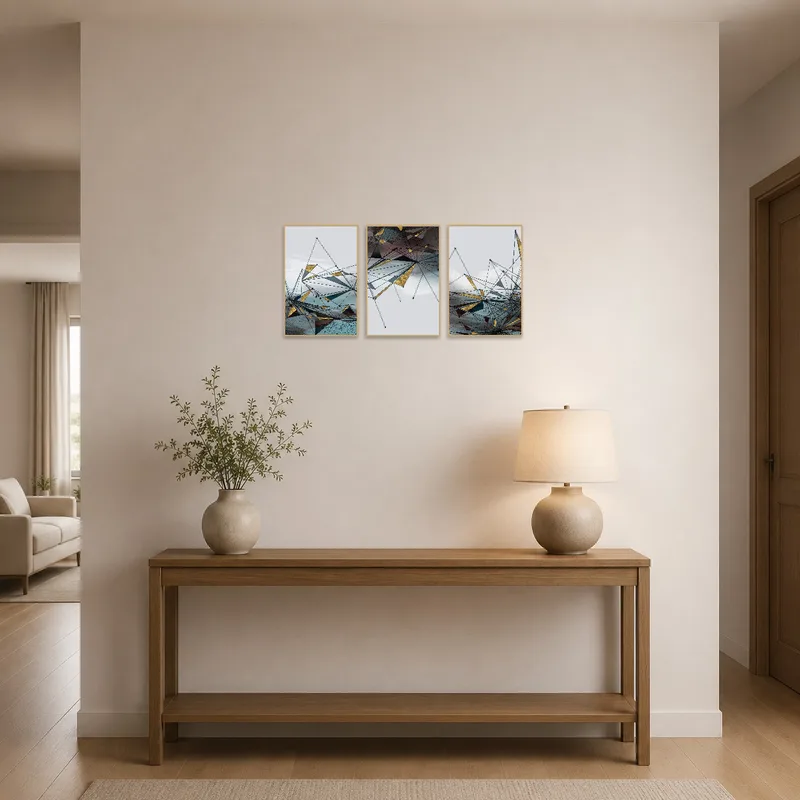 Geometric abstract triptych with gold accents in an entrance hall near a stylish console table.