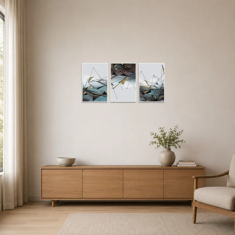 Geometric abstract triptych with gold accents in a minimalist room with sleek furnishings.