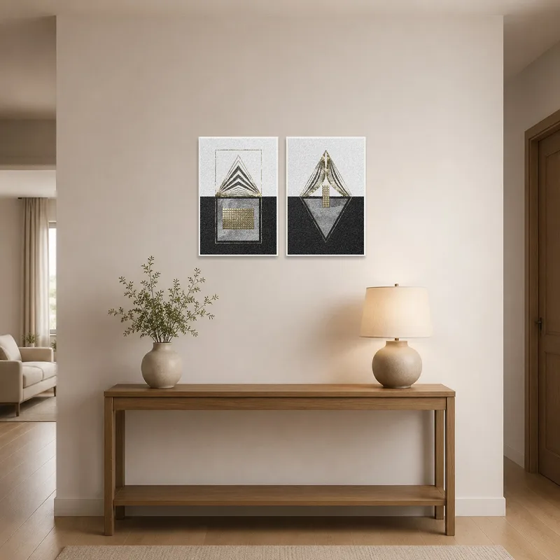 Gold and black geometric art set displayed in an entrance hall above a dark console table.