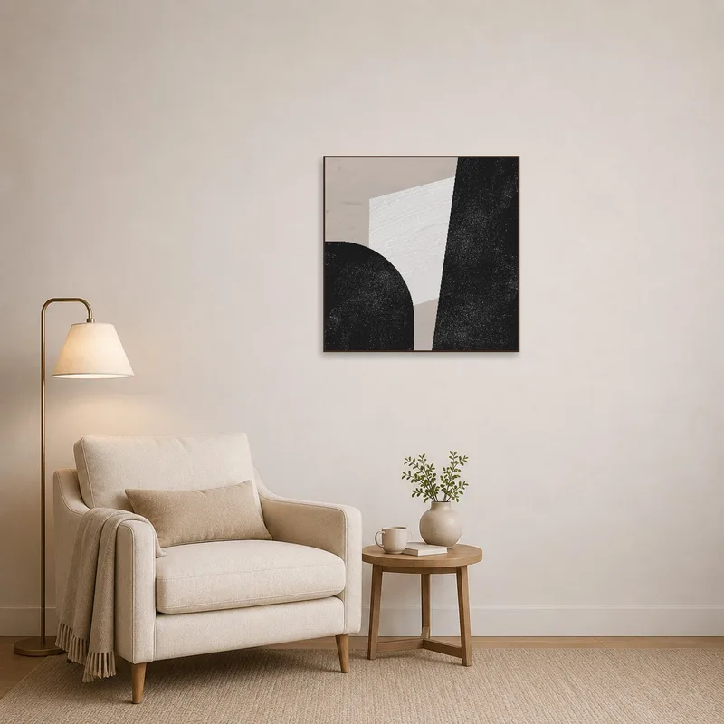 A cozy reading corner complemented by a monochrome geometric abstract art print on the wall.